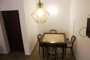 a dining room with a table and a chandelier at RIO CASA , Private villa in soochipara in Meppādi