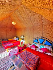 a room with three beds in a tent at Bivouac Luna in Mhamid