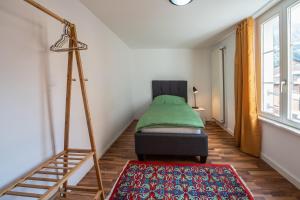 a small bedroom with a bed and a ladder at Schützenmatt Ferienwohnung in Altdorf