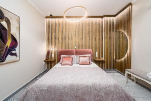 a bedroom with a bed with two pink pillows at Meltemi Beach House - a seaside Luxury maisonnette in Dhiyeliótika
