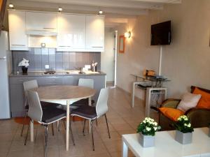 cocina y sala de estar con mesa y sillas en Gîtes L'Art d'une Pause, en Champagny-sous-Uxelles
