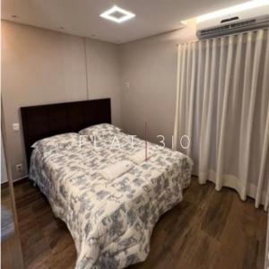 ein Schlafzimmer mit einem Bett mit einer Decke darauf in der Unterkunft flat em são vicente in São Vicente
