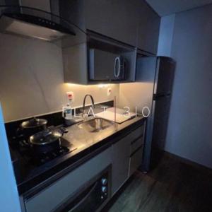 a kitchen with a stove and a sink and a refrigerator at flat em são vicente in São Vicente