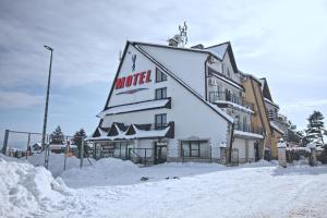 a large building with a sign on it in the snow at Motel Na Zbójeckiej in Skawa