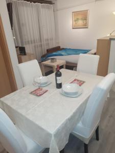 uma mesa branca com dois copos e uma garrafa de vinho em Apartman Ciblja em Velika Gorica