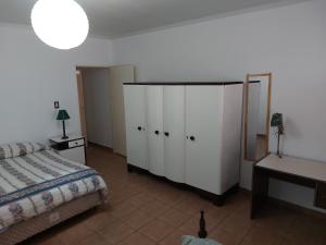 1 dormitorio con cama, armarios blancos y escritorio en Departamento G Cruz - Talca 1 con cochera en Godoy Cruz