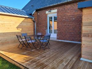a wooden deck with a table and chairs on it at Le 14 in Roye