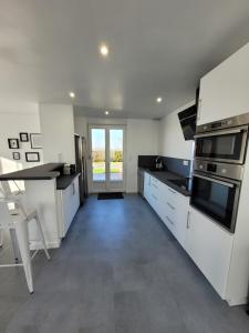 a kitchen with white appliances and a large window at Le 14 in Roye