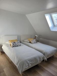 two beds in a room with white walls and windows at Le 14 in Roye
