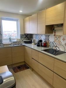 a kitchen with wooden cabinets and a window at 2 Bedroom Chelsea Apartment in London