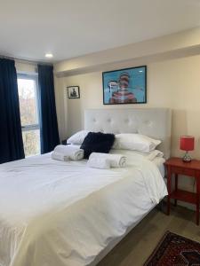 a bedroom with a large white bed with a picture on the wall at 2 Bedroom Chelsea Apartment in London