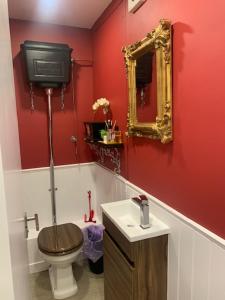 a bathroom with a toilet and a sink and a mirror at 2 Bedroom Chelsea Apartment in London