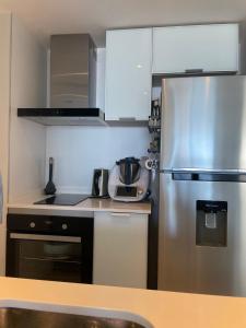 una pequeña cocina con nevera de acero inoxidable en ARTOWER - Ocean View 1 bedroom apartment, en Punta del Este