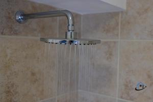 a shower head with water hanging from it at The Old Plough, rustic flat, super king bed or twins, en-suite, secure parking, free wi-fi, corporates welcome in Caldecott