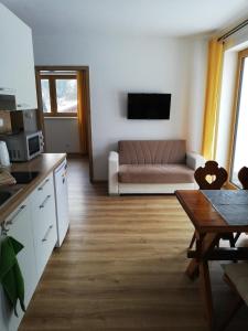 Apartmány Horní Bečva في هورني بيسافا: مطبخ وغرفة معيشة مع أريكة وطاولة