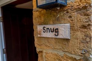 a sign that reads sing on a stone wall at The Old Plough, rustic flat, super king bed or twins, en-suite, secure parking, free wi-fi, corporates welcome in Caldecott