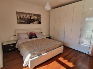 a bedroom with a bed and a painting on the wall at Appartamento Volta in Rho