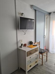 a room with a dresser and a tv on a wall at Appartement avec vue sur le lac in Vieux-Boucau-les-Bains