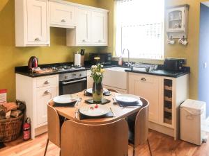 a kitchen with a table with chairs and a sink at City Cottage in Liberton