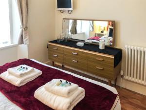 a bedroom with two towels on a bed with a mirror at City Cottage in Liberton