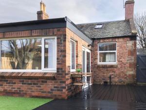 a brick house with a large window and a deck at City Cottage in Liberton