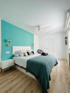 a bedroom with a bed with a blue wall at VIP -Apartamentos Birdie- in Albacete