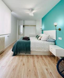 a bedroom with a bed and a blue wall at VIP -Apartamentos Birdie- in Albacete