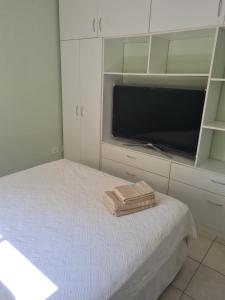 1 dormitorio con TV y 1 cama con toallas. en Dpto corriente capital en Corrientes