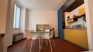 een keuken met een tafel en stoelen in een kamer bij Sandro's Home 2 in Bergamo