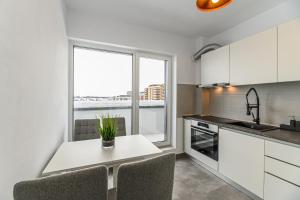 a kitchen with a table with chairs and a window at Nubia Apartment in Braşov