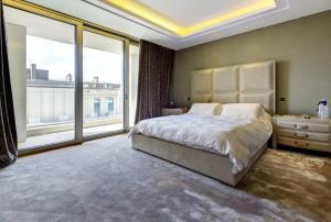a bedroom with a large bed and a large window at Luxurious flat with four bedrooms in London