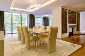 a dining room with a table and yellow chairs at Luxurious flat with four bedrooms in London