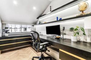 a home office with a desk and a computer at Luxurious flat with four bedrooms in London