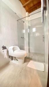 a bathroom with a toilet and a glass shower at Hotel Dorado San Luis in San Luis