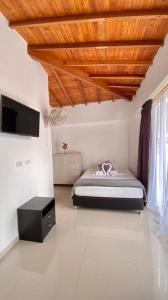 een slaapkamer met een bed en een houten plafond bij Hotel Dorado San Luis in San Luis