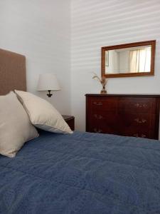 - une chambre avec un lit bleu et un miroir dans l'établissement El Abedul-B-Departamento entero en pleno centro, à Lobos