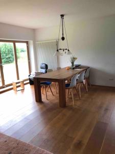 a dining room with a wooden table and chairs at Erholung auf dem Land zwischen Ostsee und Schlei in Stoltebüll