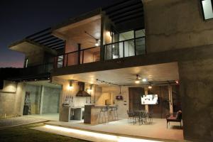 a large house with a kitchen and dining area at night at Casa en Allende con alberca (Casa Guaname) 