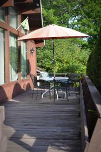 a table and chairs with an umbrella on a deck at Lake Moc A Tek Inn in Lakeville