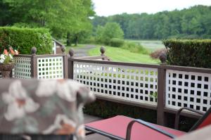 een terras met een hek en een tafel en stoelen bij Lake Moc A Tek Inn in Lakeville