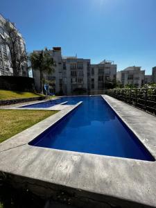 uma grande piscina com água azul em frente aos edifícios em Piso Luna em Emiliano Zapata