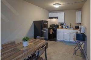 a kitchen with a black refrigerator and a table at Gorgeous Guesthouse Near Amazing Downtown in San Antonio