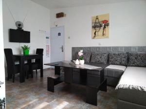 uma sala de estar com um sofá, uma mesa e um piano em SAN em Vranje