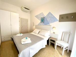 niewielka sypialnia z łóżkiem i krzesłem w obiekcie Alevon Hotel w Rimini