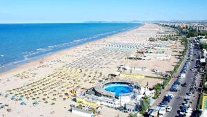a view of a beach with umbrellas and the ocean at Alevon Hotel in Rimini