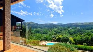 ヴィエイラ・ド・ミーニョにあるQuinta Cercas da Costaのスイミングプールと山々の景色を望む家