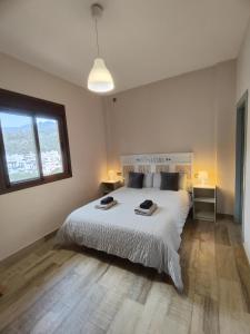 - une chambre avec un grand lit blanc et une fenêtre dans l'établissement Casa Rural Sierra De Las Nieves, à Tolox