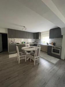 a kitchen with a table and chairs in it at Antic Apartment in Požarevac