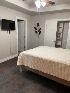 een slaapkamer met een bed en een flatscreen-tv bij Beautiful Home Fully Equipped, Sleeps 8! in Springdale