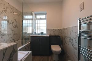 a bathroom with a toilet and a sink at Onyx - 3 Bedroom House in Southampton